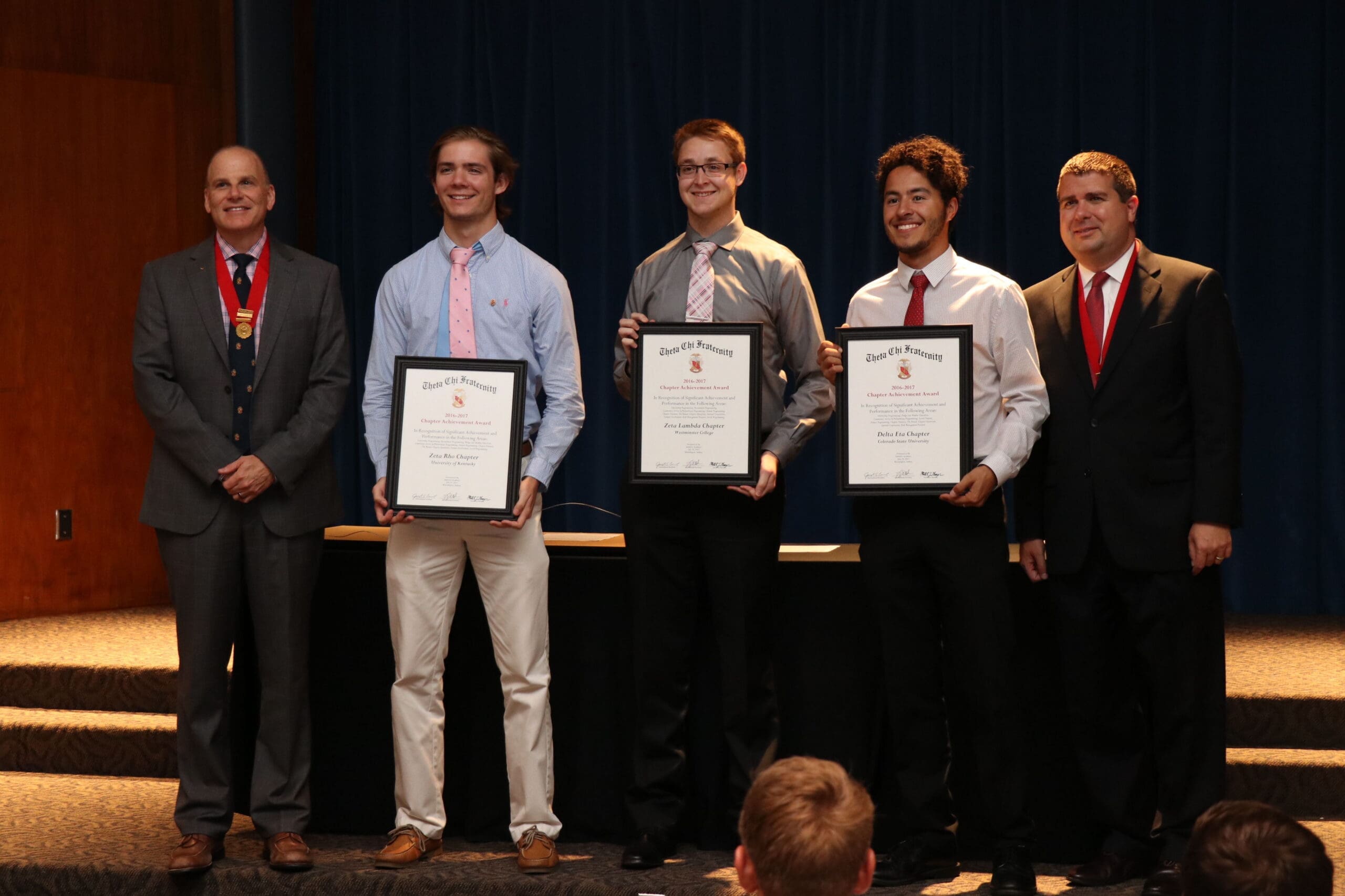 Students receiving awards at a formal ceremony.