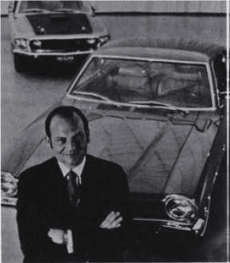 Lee Iacocca Businessman posing with classic cars in showroom.