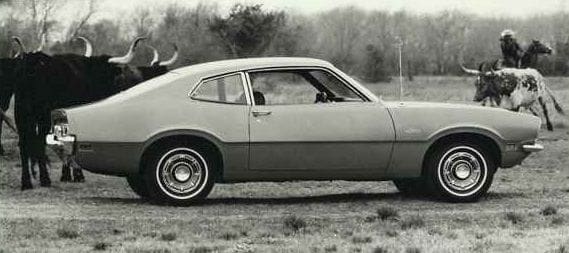 Lee Iacocca Classic car in a rural setting with bull.
