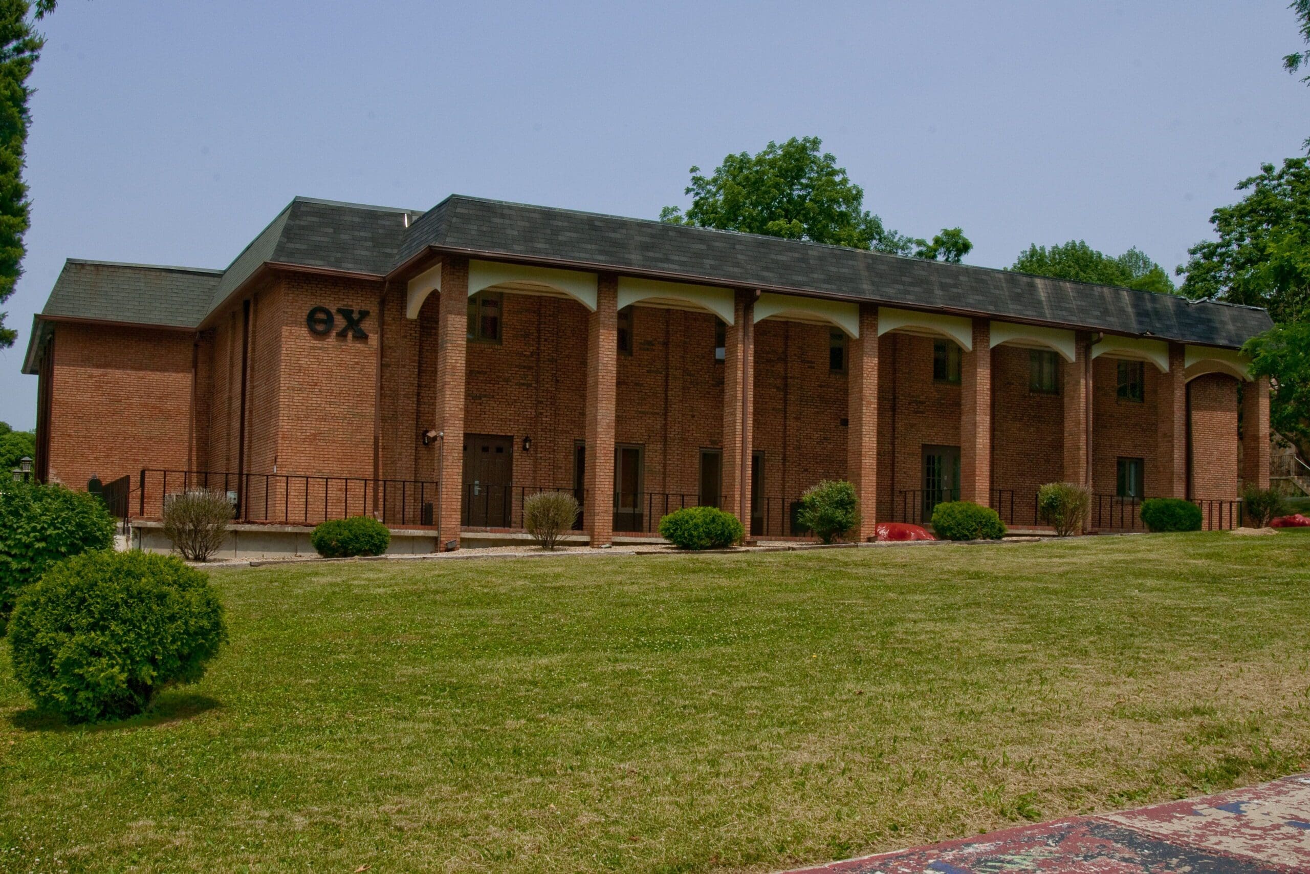 Alpha Iota - Indiana Brick building with columns and green lawn.