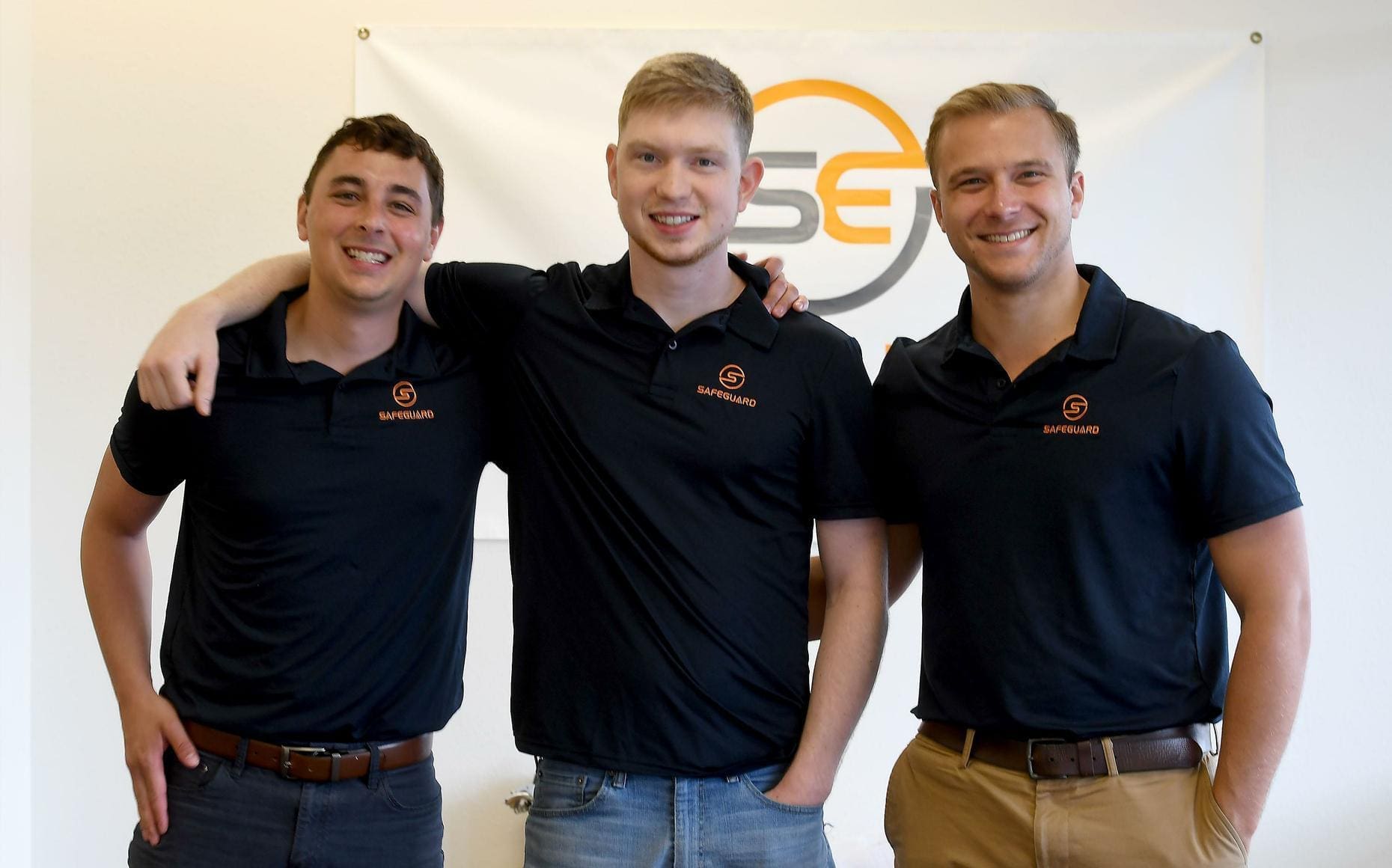 Idaho - Safeguard Three smiling men in branded polo shirts.
