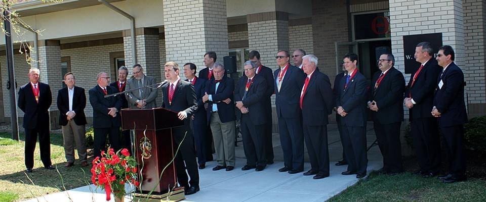 Ceremony with speakers and attendees in formal attire.