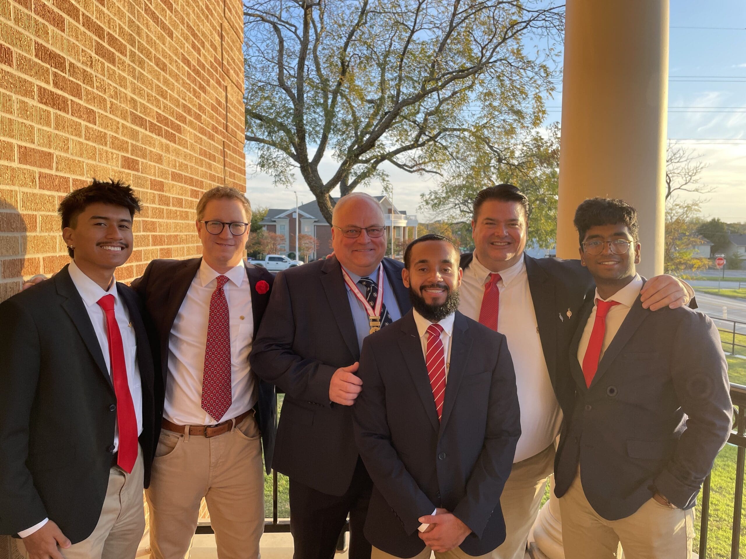 Group of men in suits celebrating an achievement.
