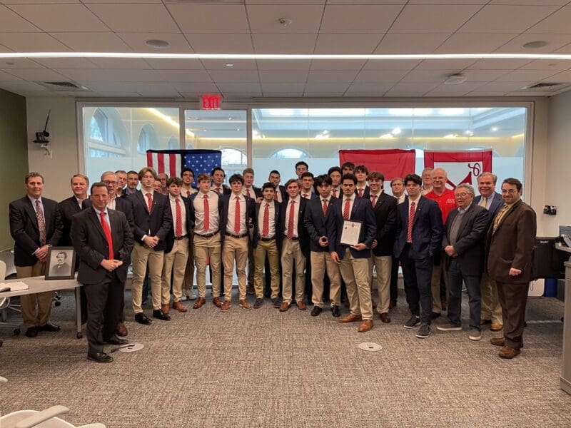 Group photo of award-winning team with flags.