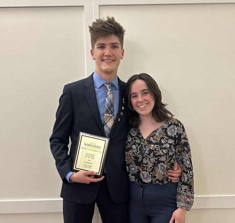 Young couple celebrating award achievement at ceremony.