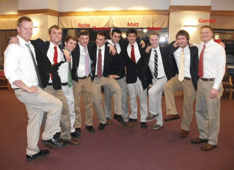 Group of men in suits posing together.