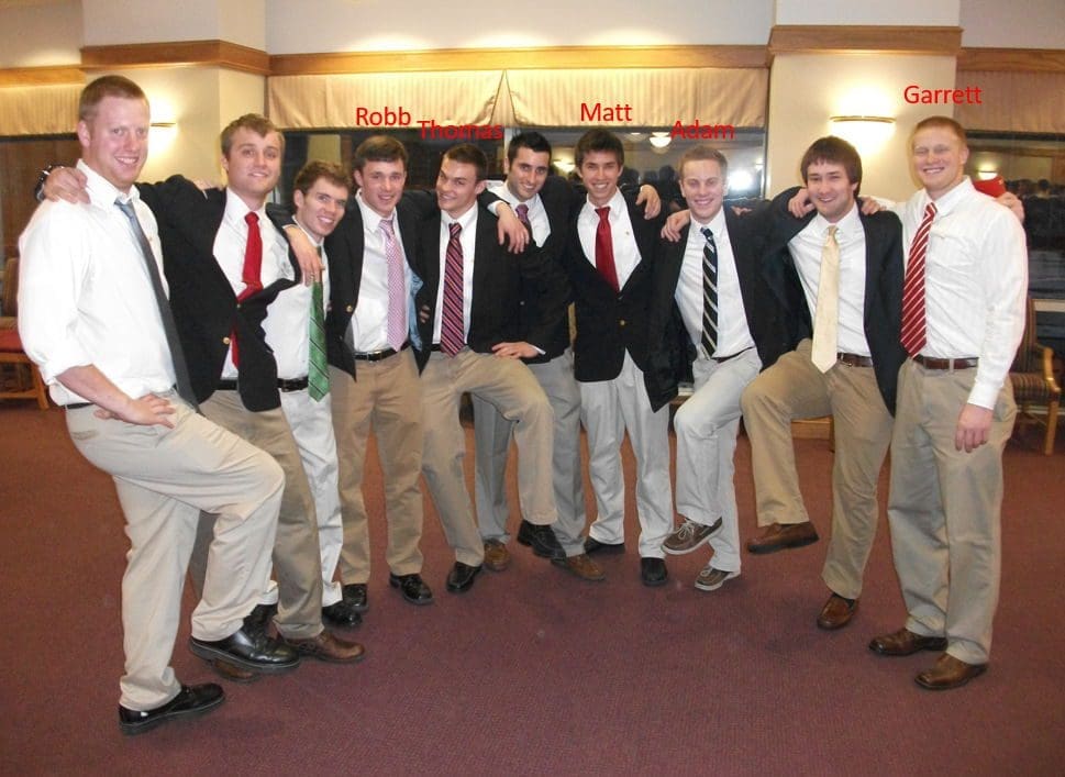 Group of men in suits posing together.