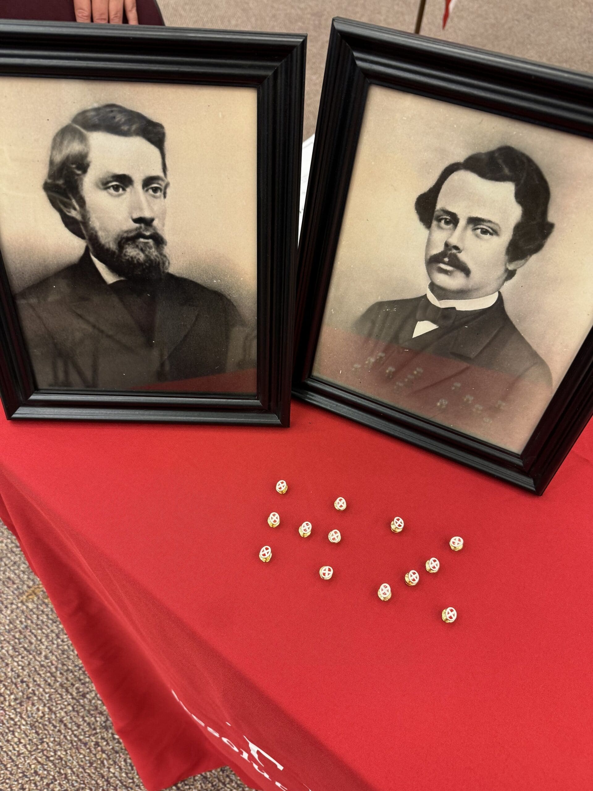 Historic portraits displayed on a red tablecloth.