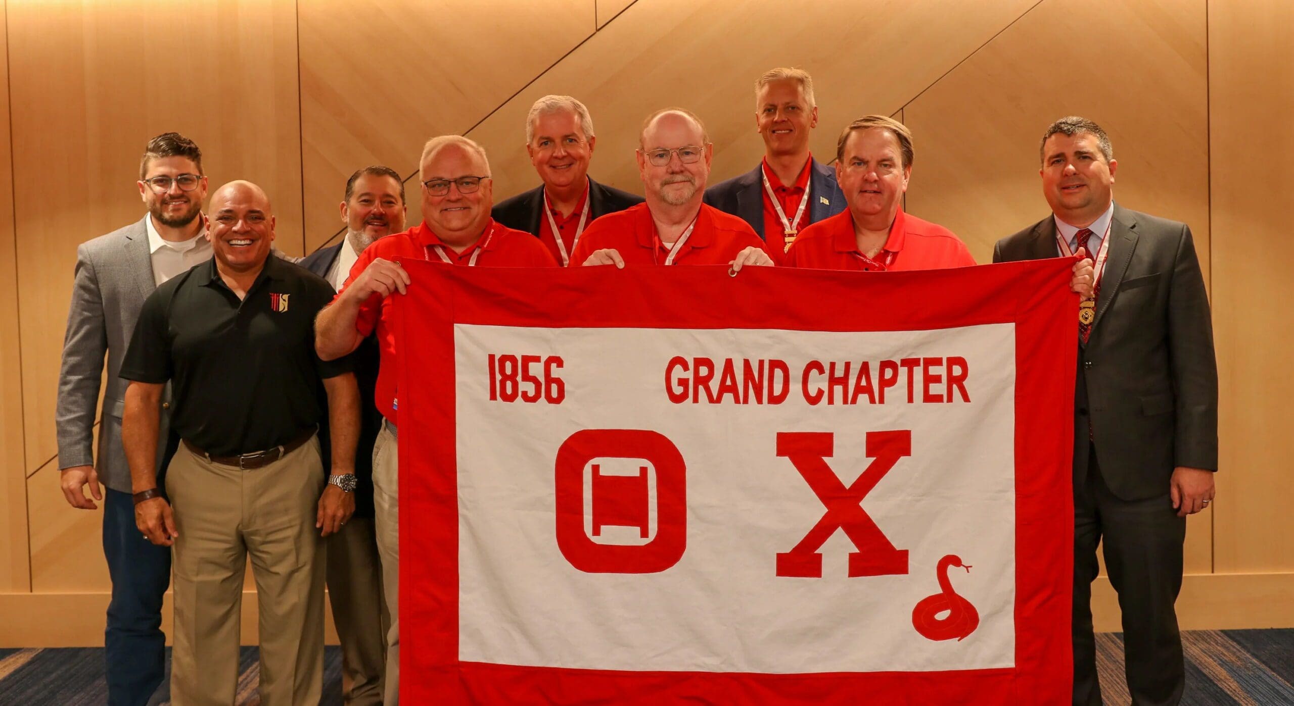 Men holding a large red banner with symbols.