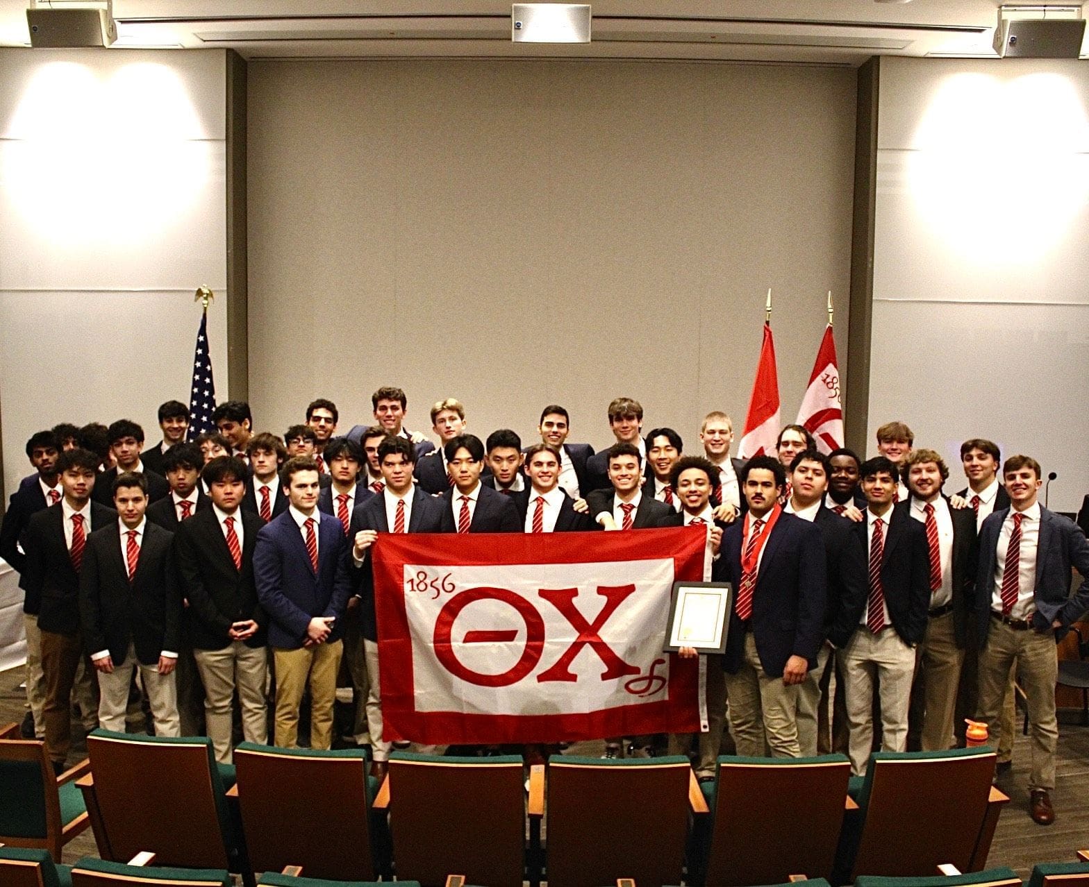 Group of students holding Theta Chi flag.
