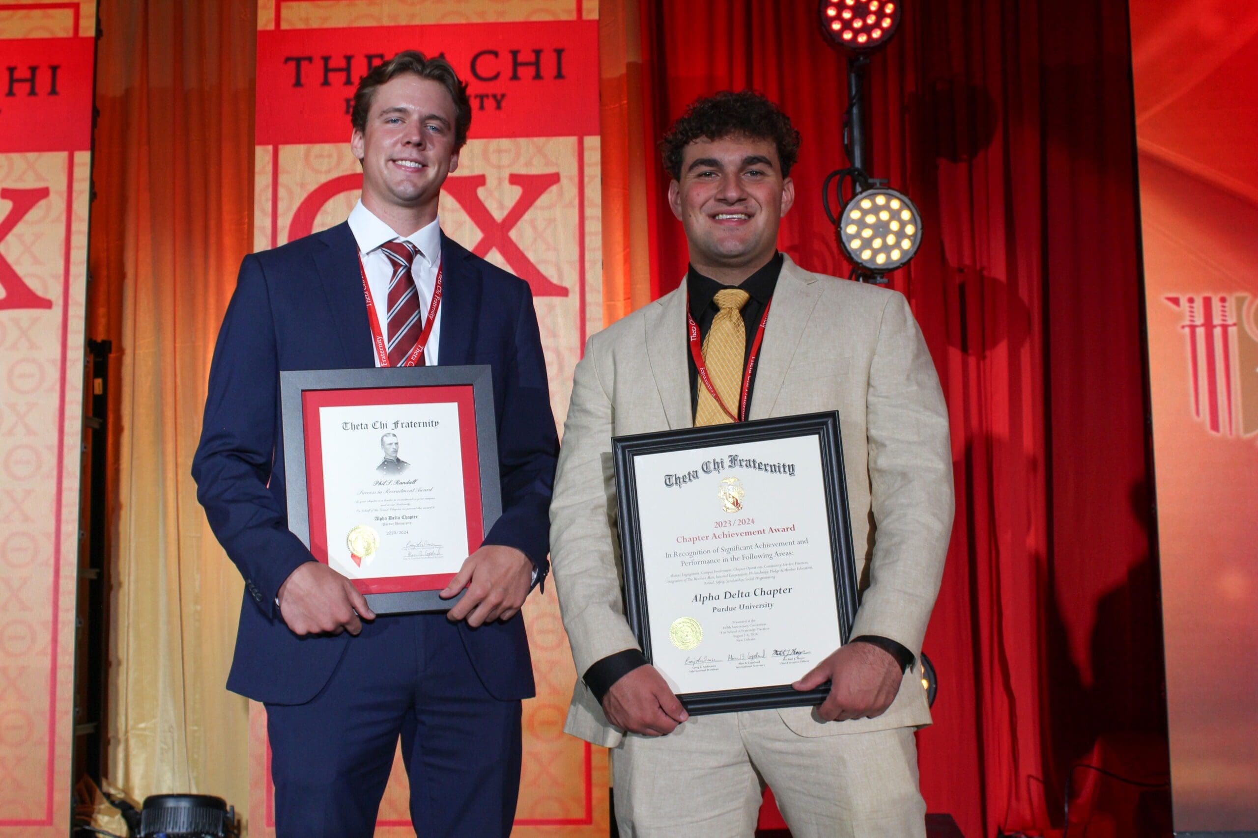 Two students holding awards at a university event.