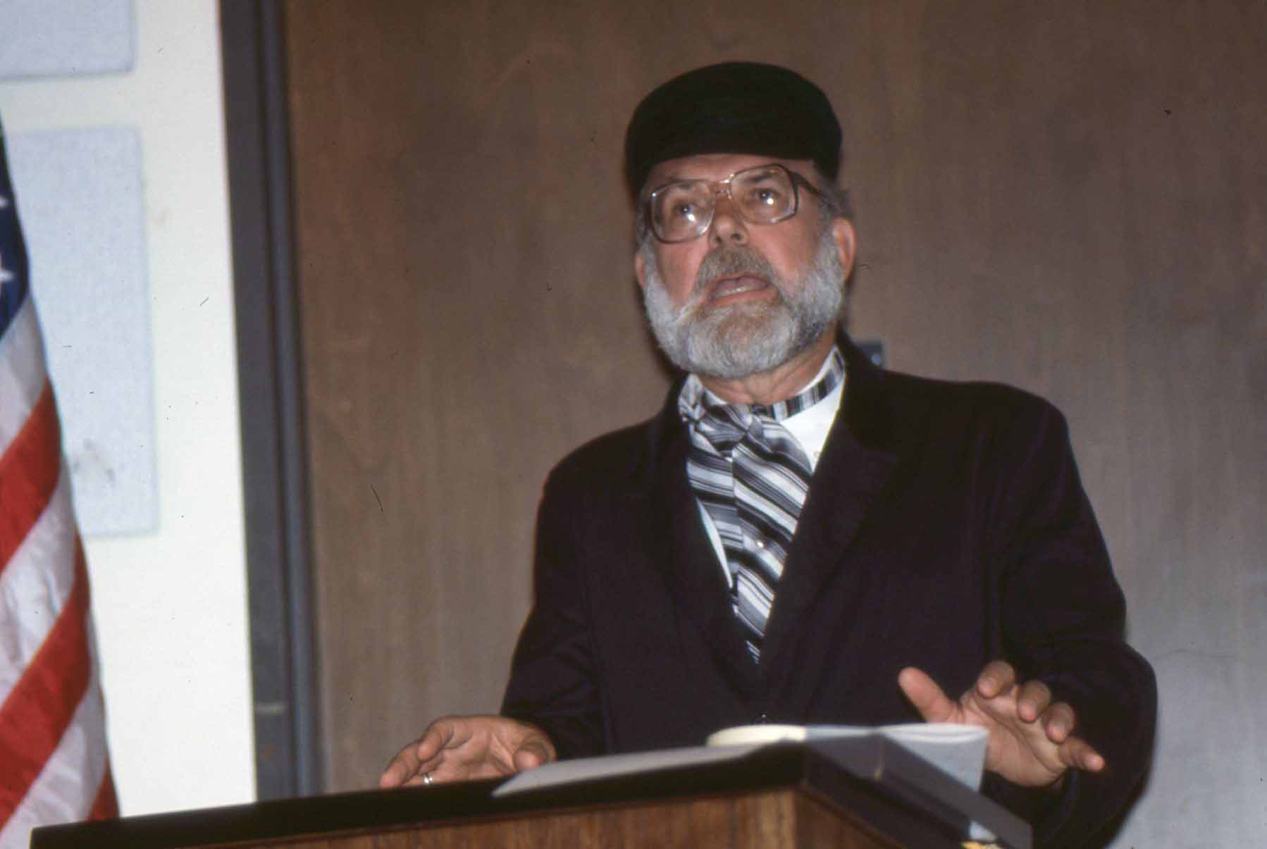 Speaker presenting at a conference with a podium.