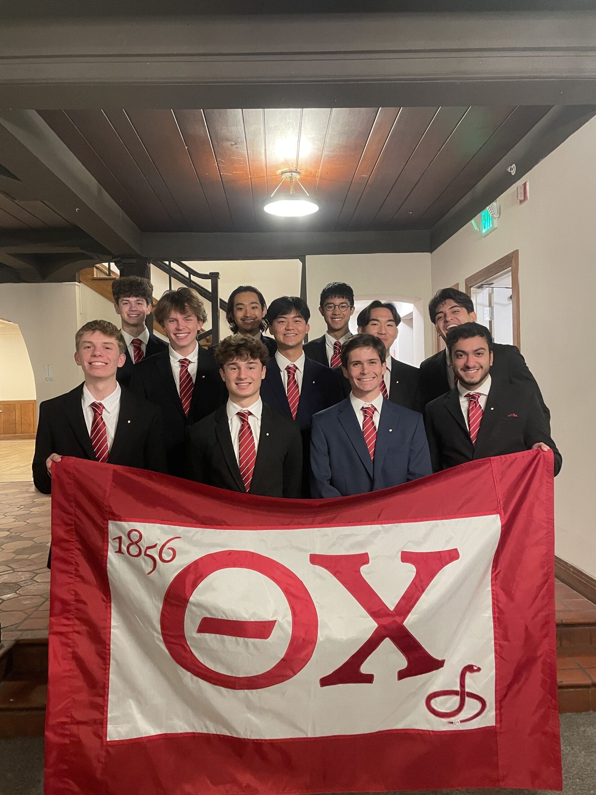 Group of fraternity members holding a flag.