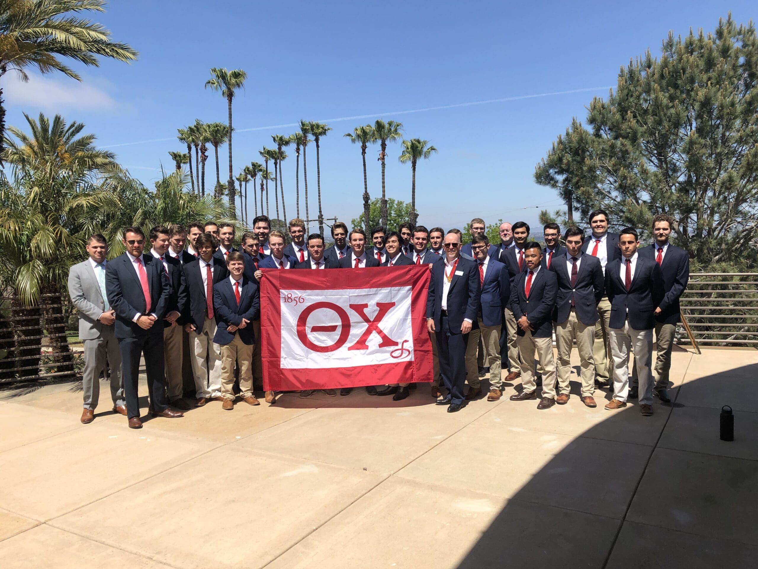 Kappa Mu - Point Loma Nazarene Group photo of fraternity members with banner.