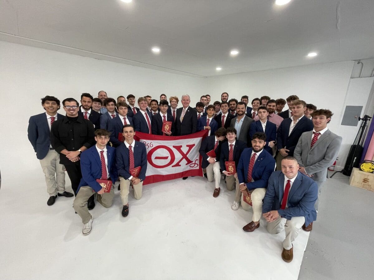 Group photo of fraternity members holding a banner.