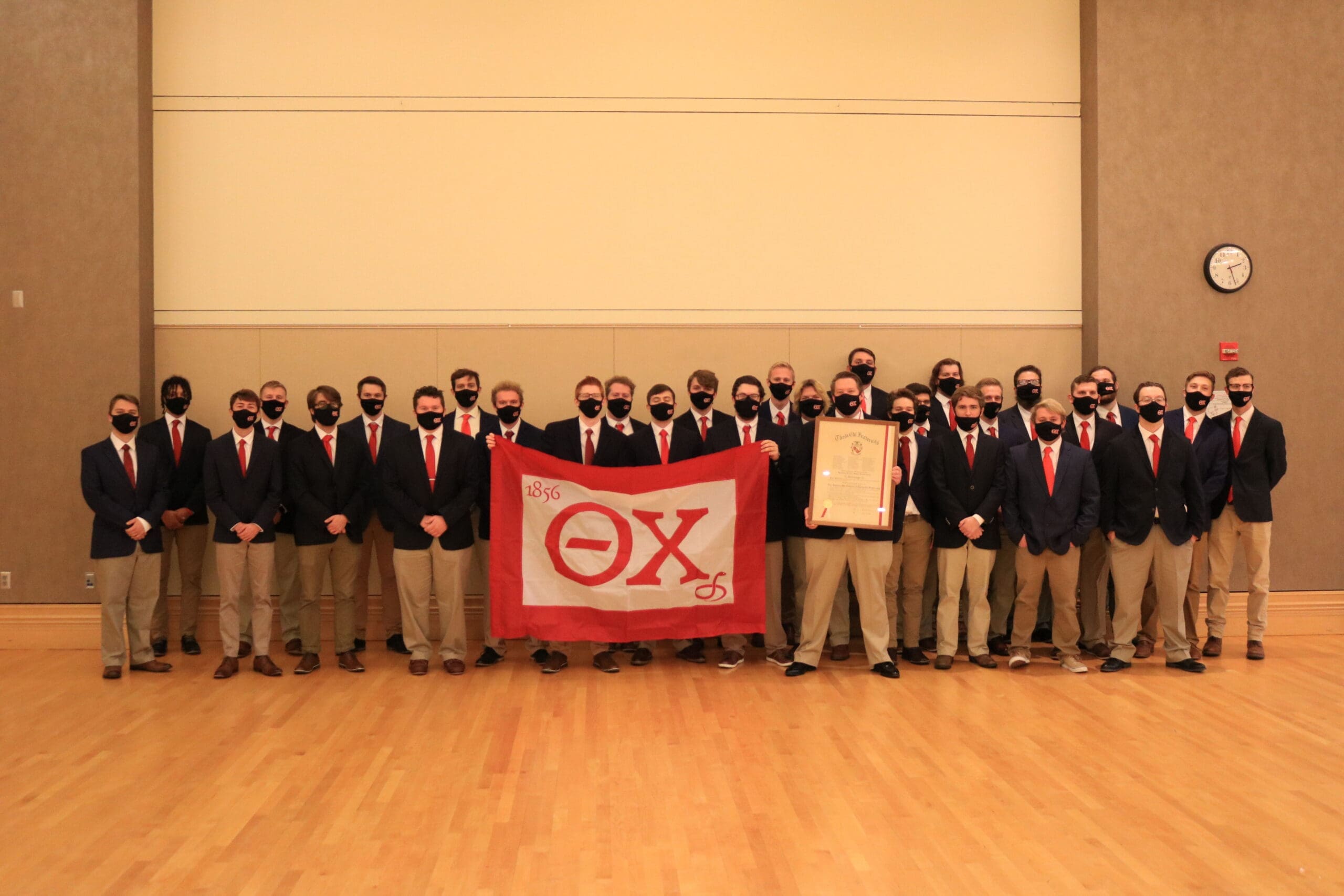 Gamma Mu - Bowling Green Group photo of fraternity members with flag.