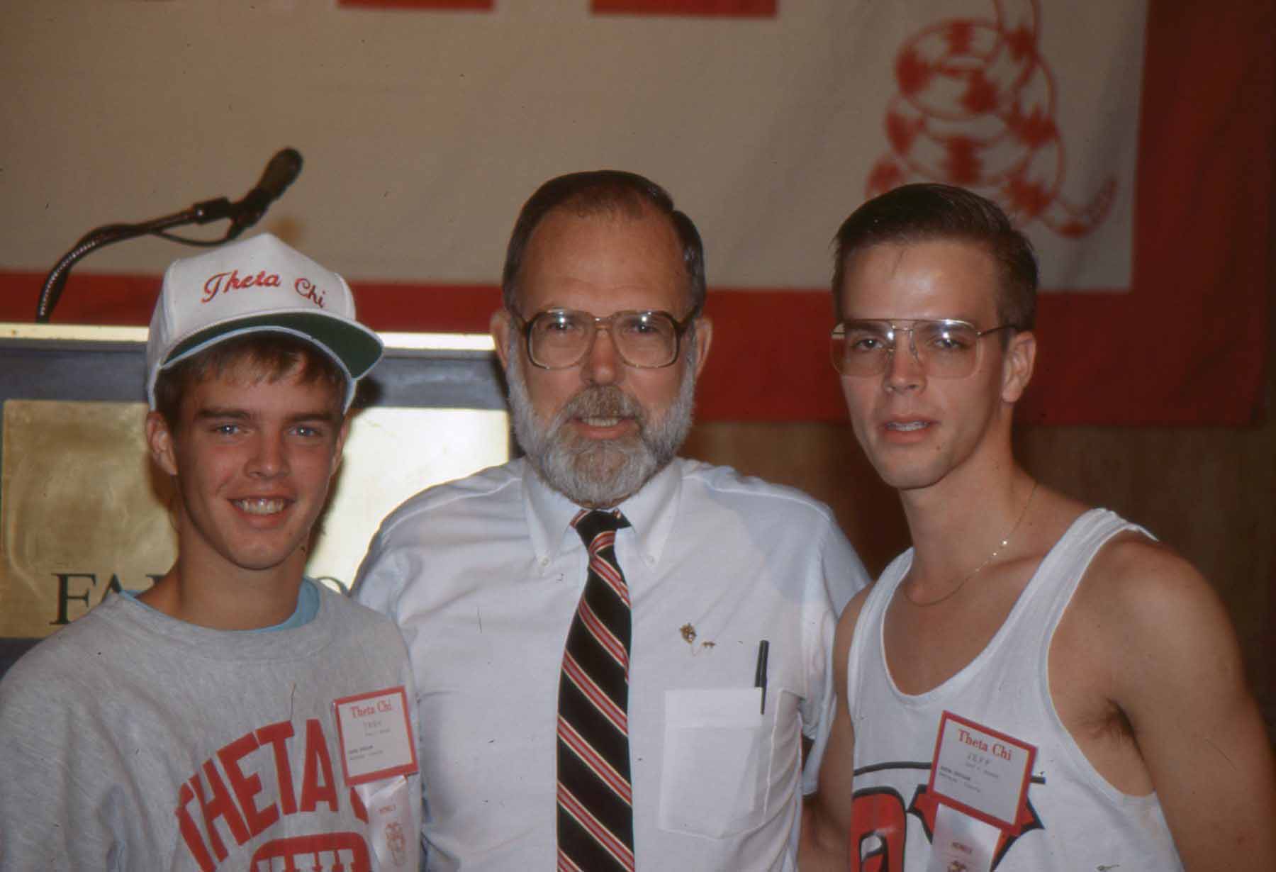 Three men posing together at a gathering.