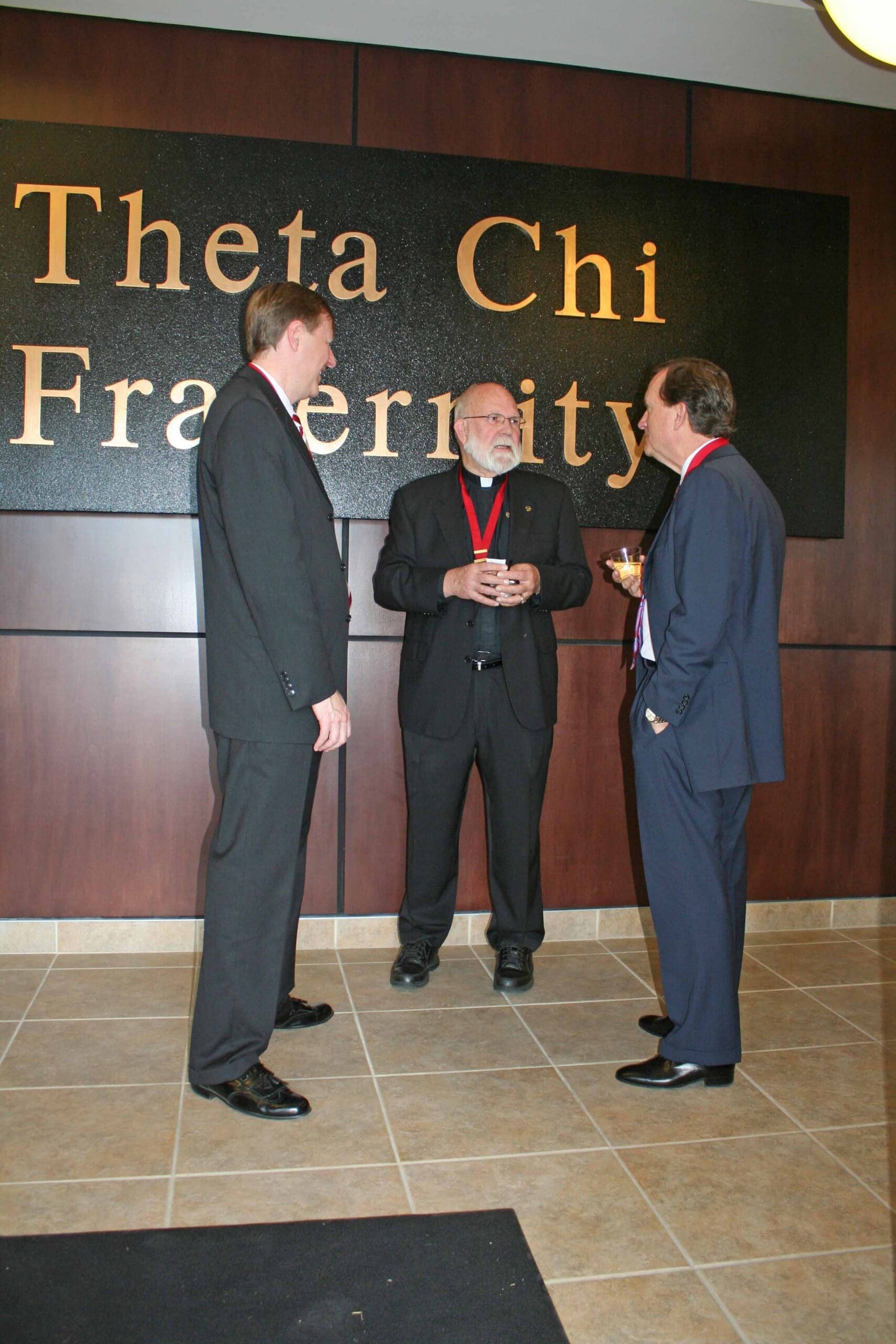 Men discussing at Theta Chi Fraternity event.