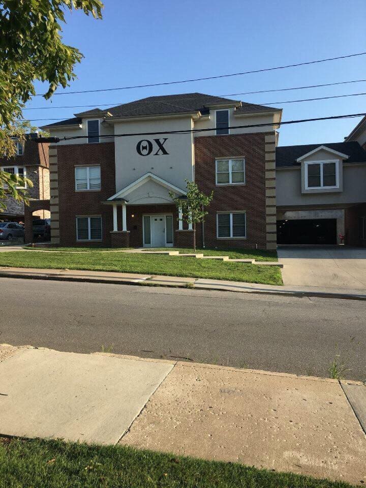 Residential building with Greek letters on facade.