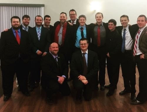 Group of men in formal attire posing together.