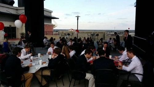 Outdoor dining event with attendees enjoying a meal.