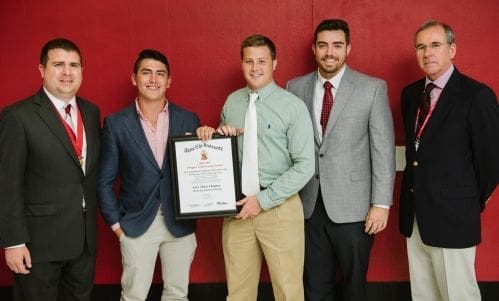 Group of men celebrating an achievement with a certificate.