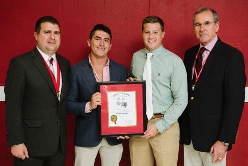 Group of four men holding award certificate.