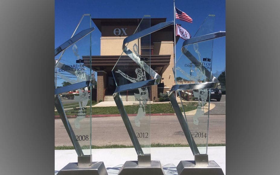 Awards displayed outside a building with flags.