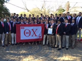 College fraternity members posing with their banner.