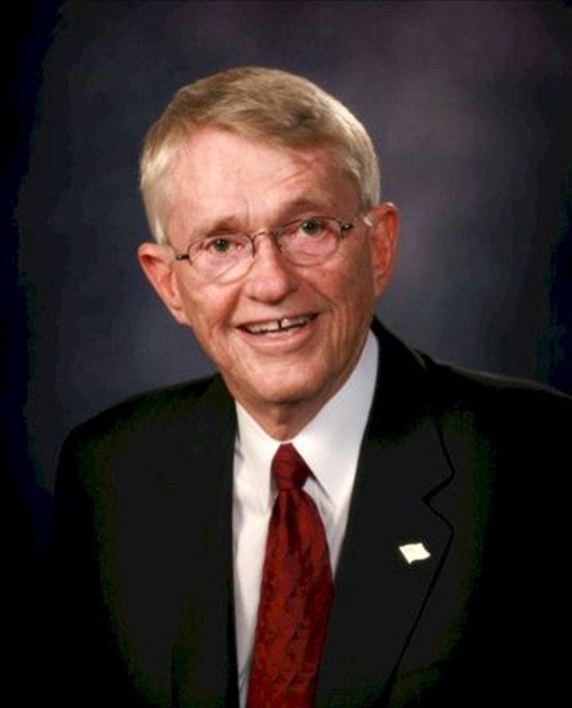 Smiling older man in a suit and tie.