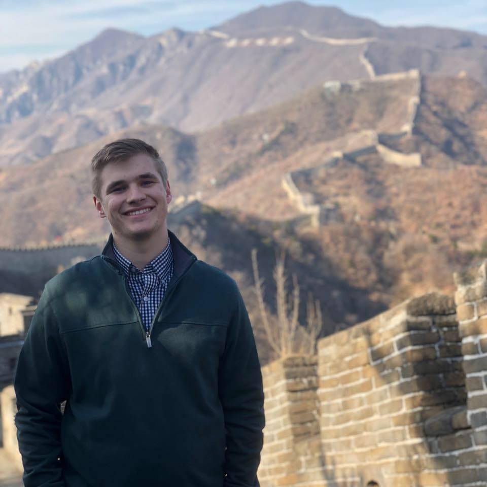 Jared Pinkerton Smiling man at Great Wall of China backdrop.