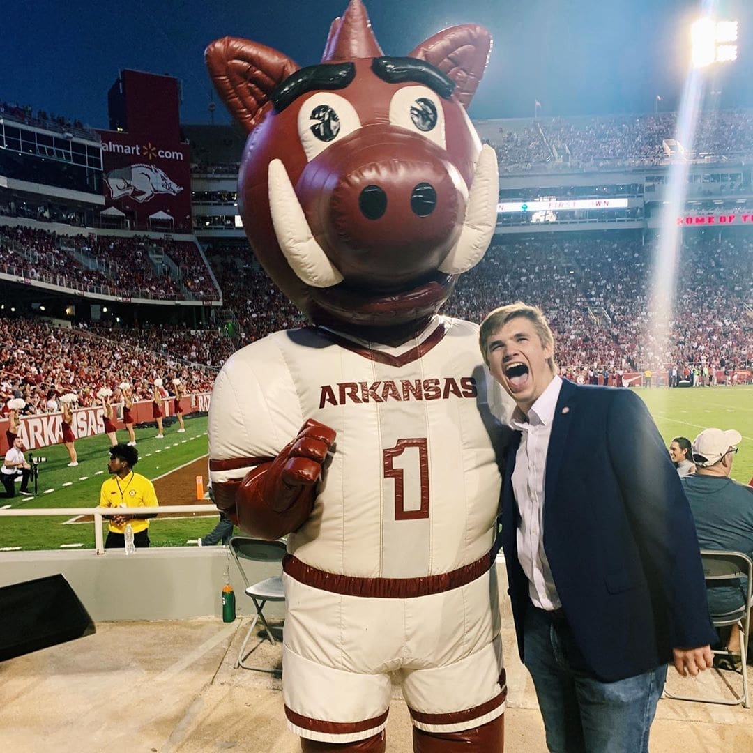 Jared Pinkerton Fan poses with Arkansas mascot at football game.