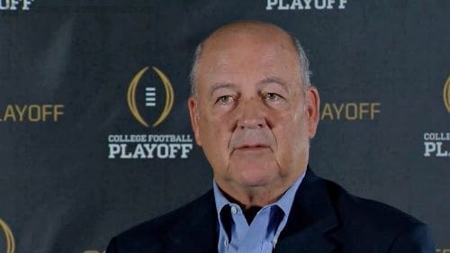 Man speaking at College Football Playoff event.