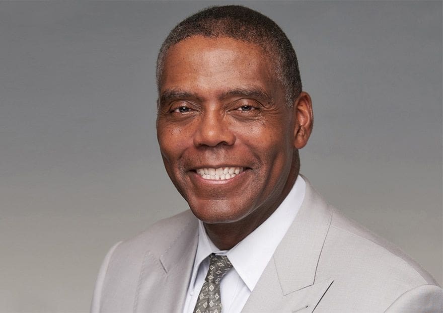 James Banks Smiling man in a light gray suit.