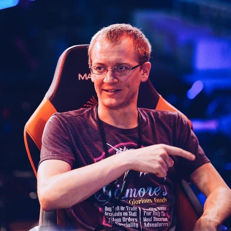 Man in gaming chair pointing during esports event.