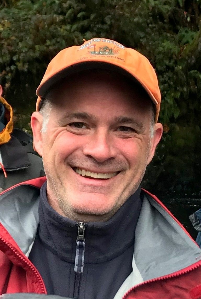 Jonathan McHugh Smiling man wearing an orange cap outdoors.