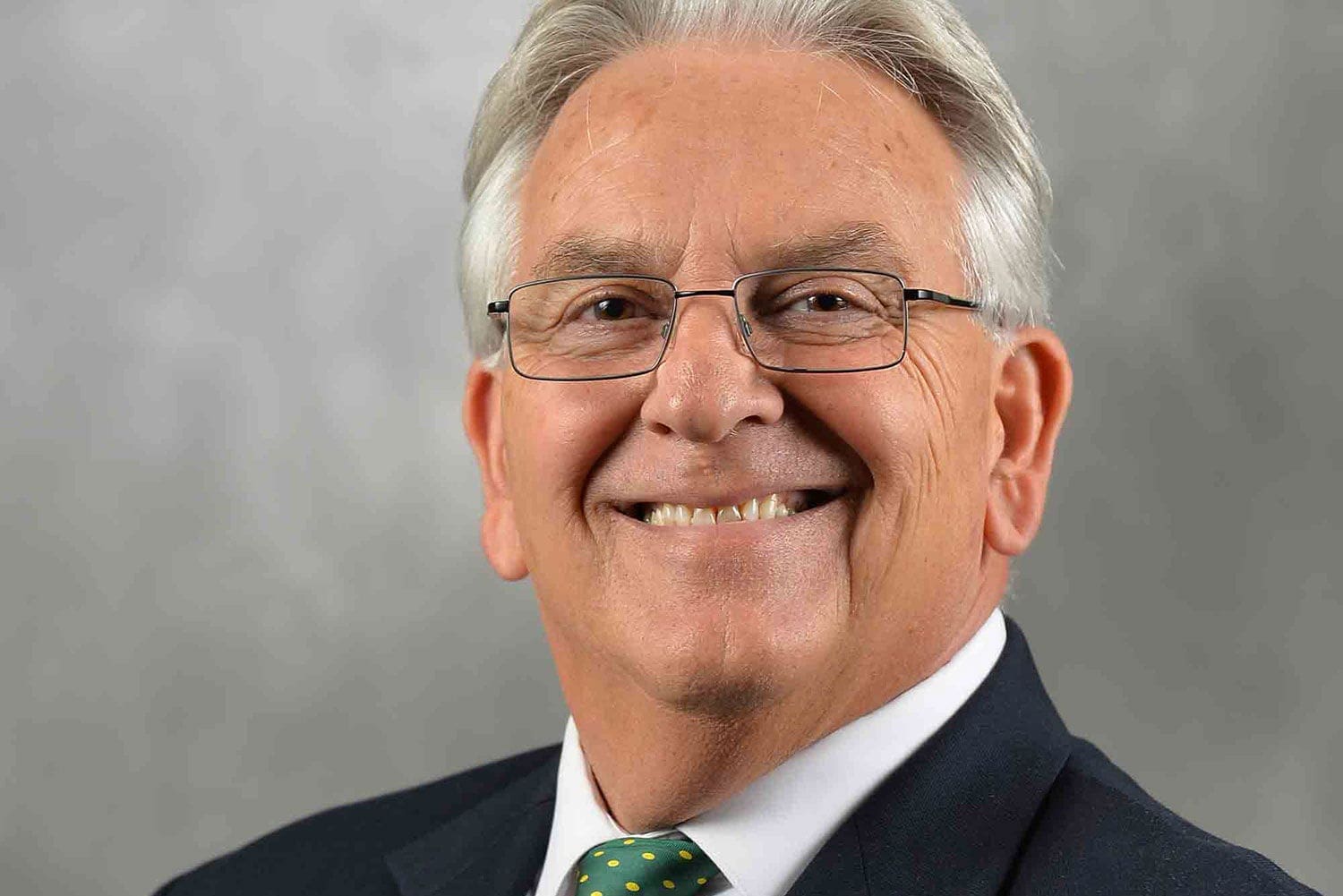 Keith Hackett - Front Page Smiling older man in professional attire.