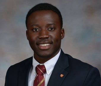Kofi Ladans Professional portrait of a smiling man in suit.