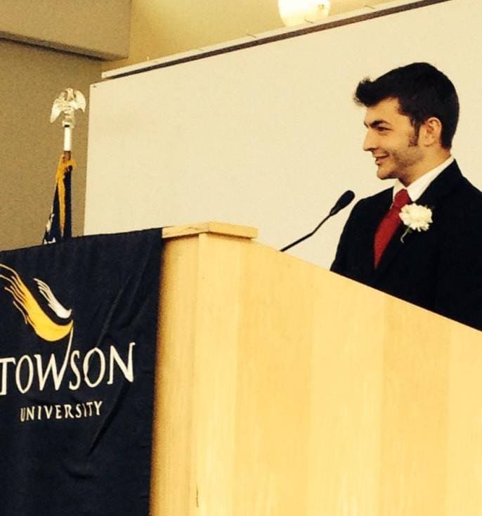 Young man speaking at Towson University event.