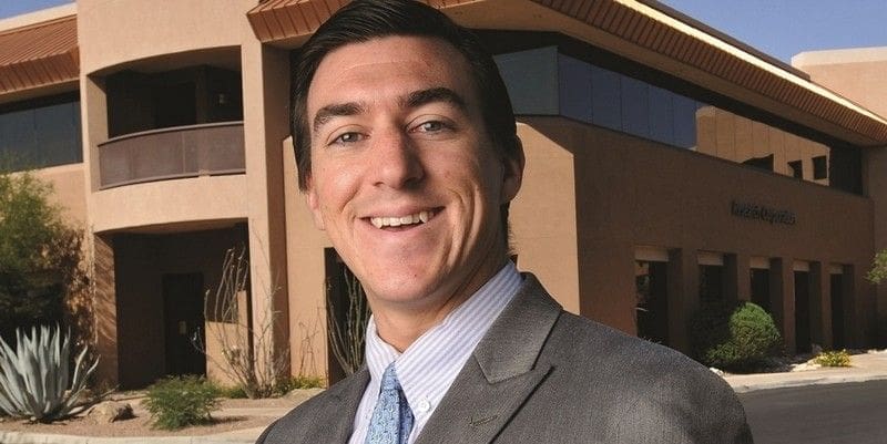 Smiling professional man in a business suit outdoors.