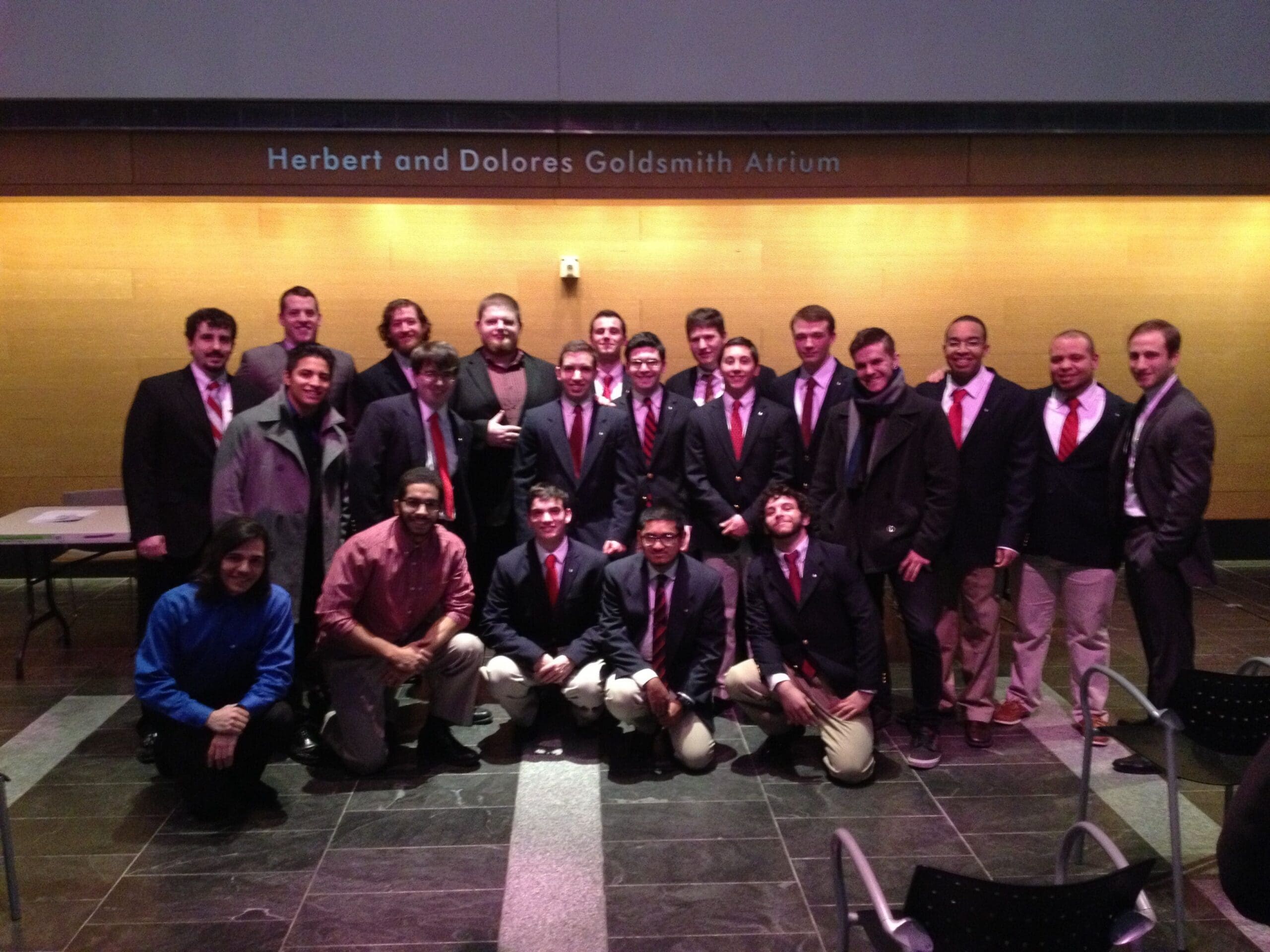 Group photo of men in formal attire at event.