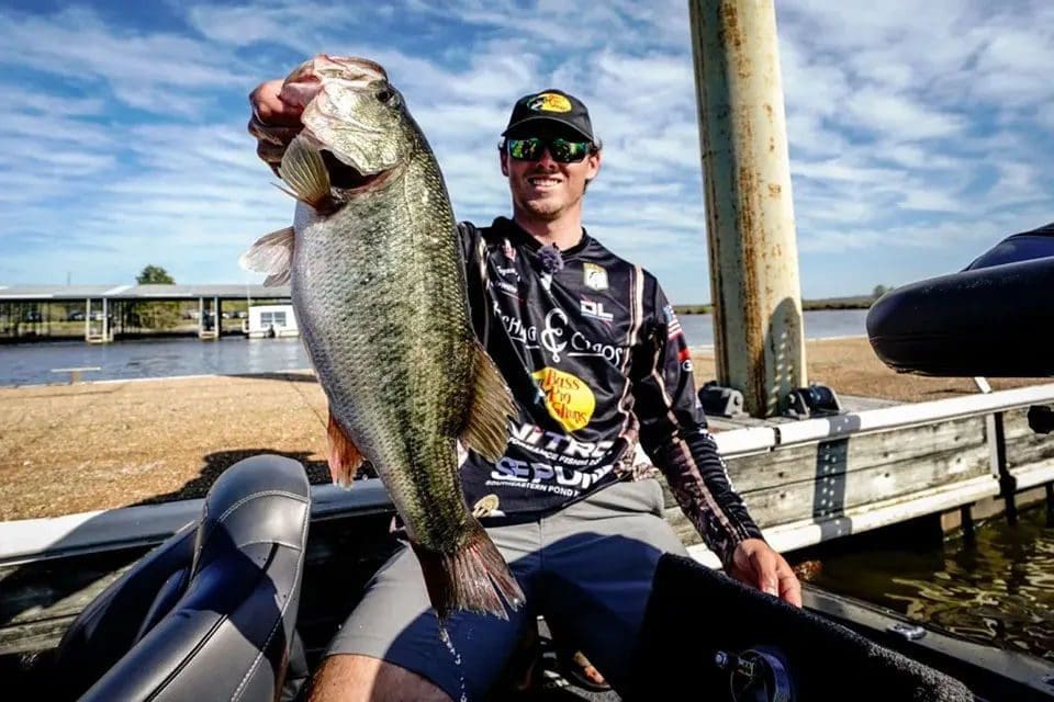 Angler proudly holding a large bass fish.