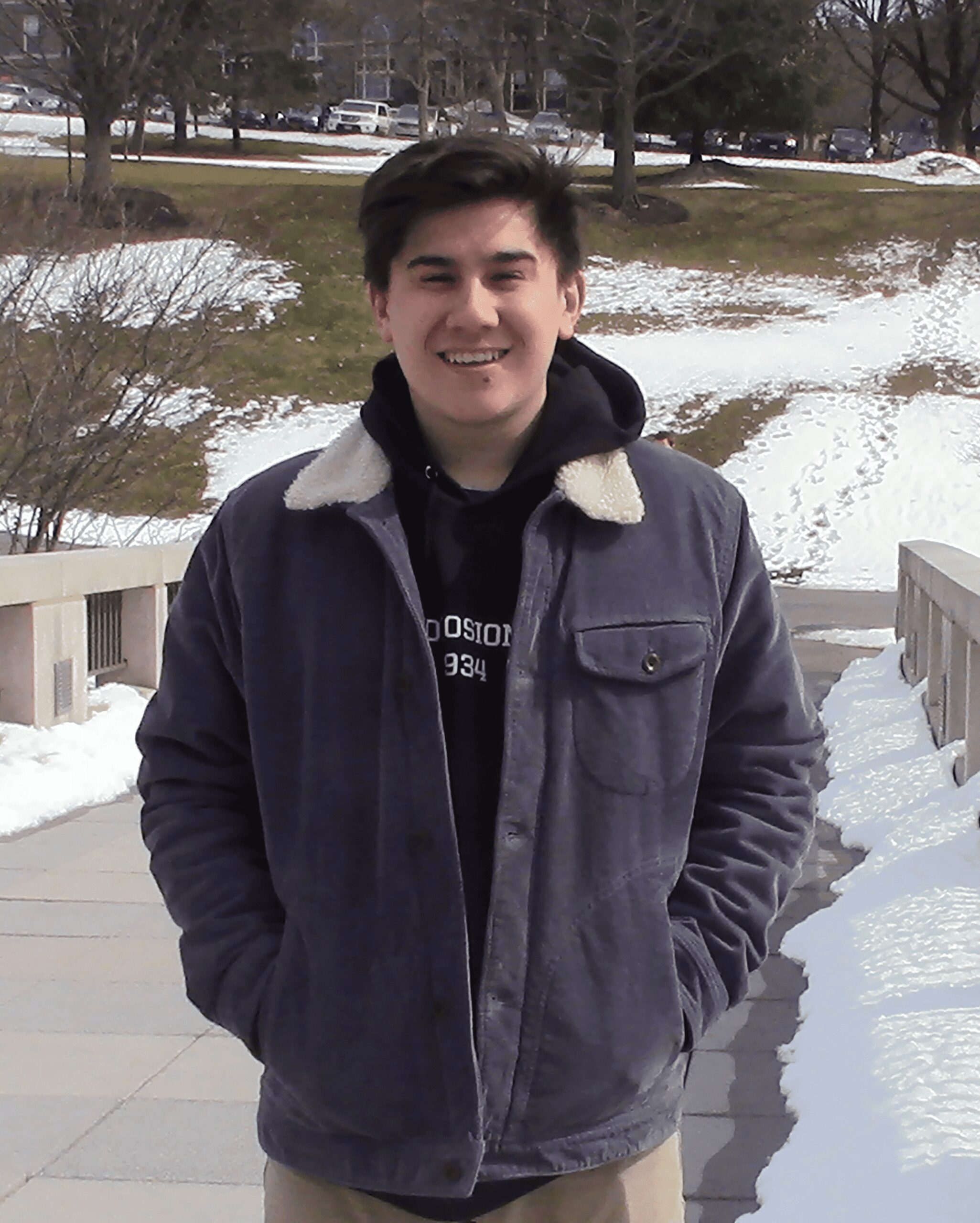 Smiling young man in winter jacket outdoors.