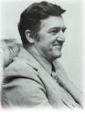 Black and white portrait of a smiling man.