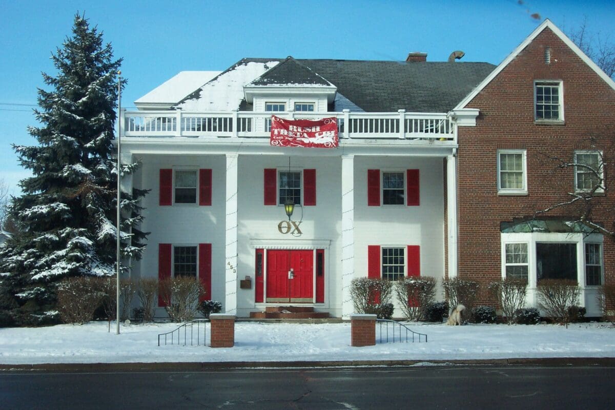 Greek life fraternity house with red accents and snow.