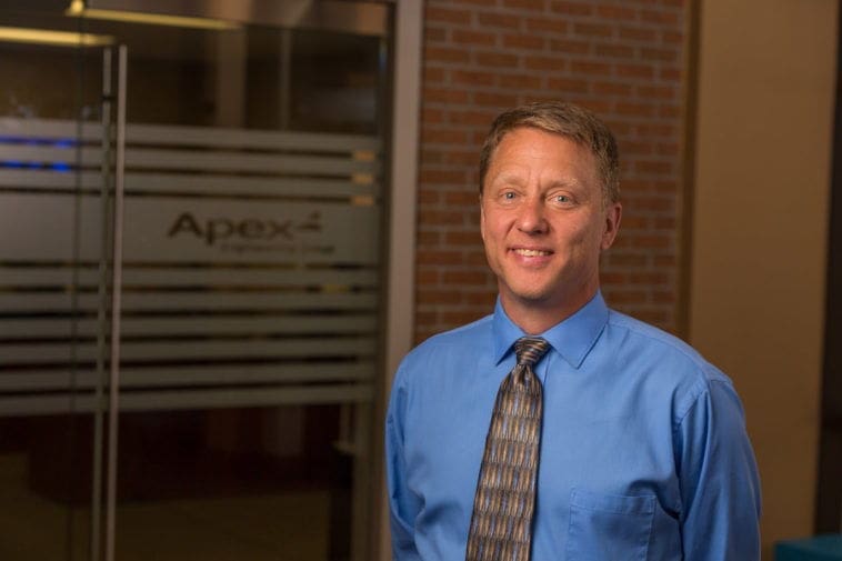 Professional man in blue shirt by Apex office.