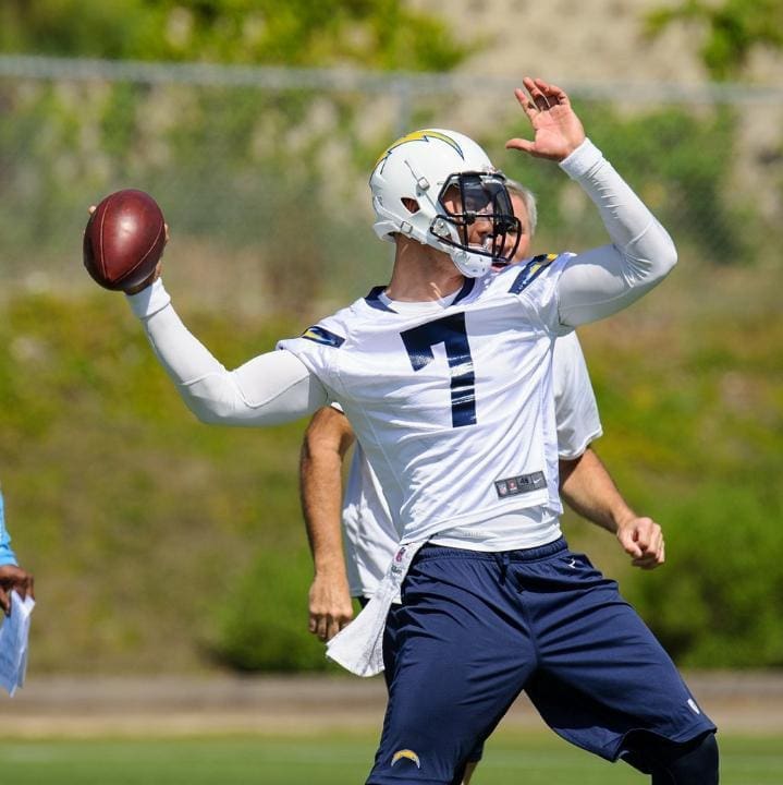 Quarterback throwing football during practice session.