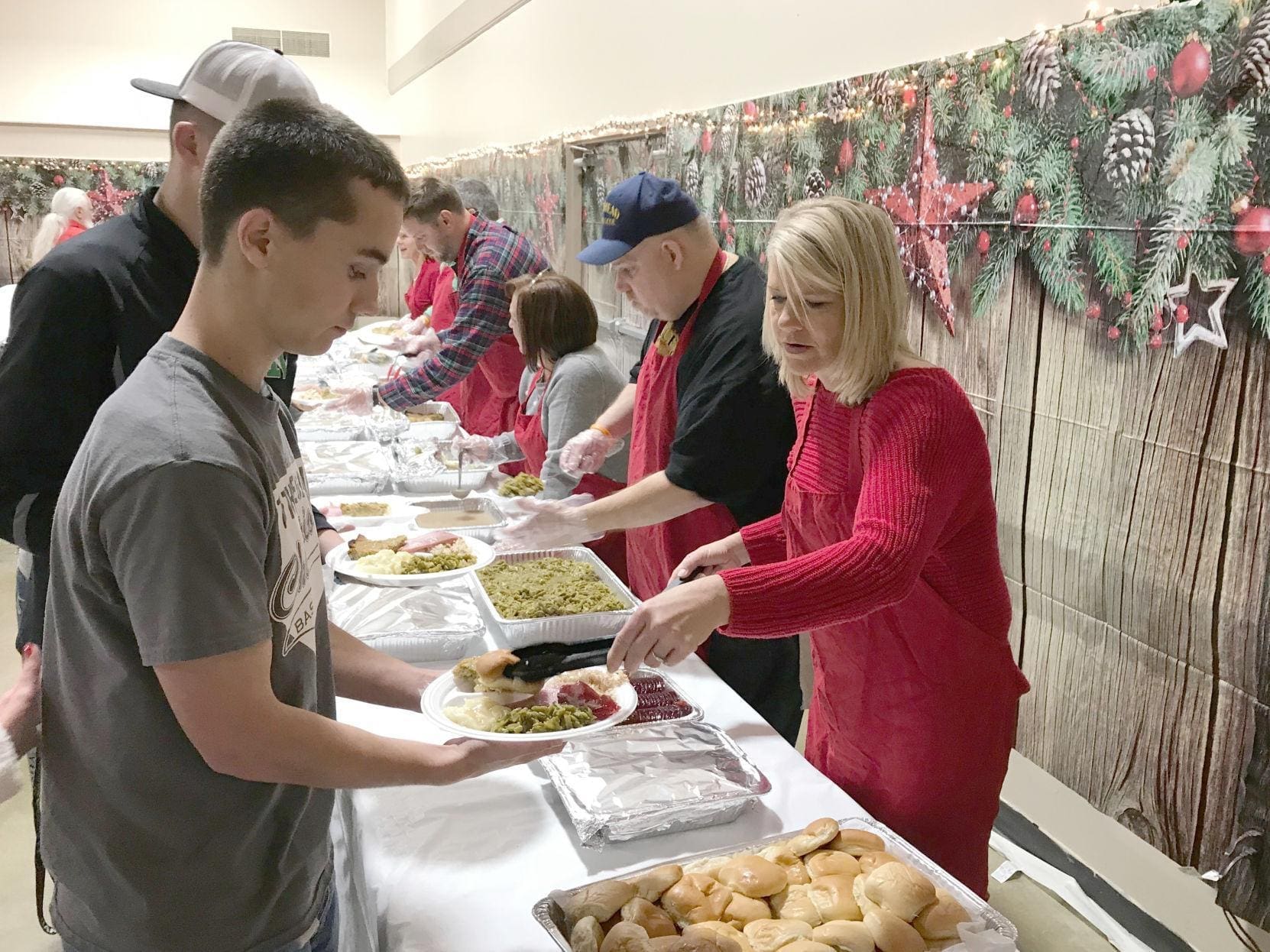 Volunteers serving food at a community meal event.