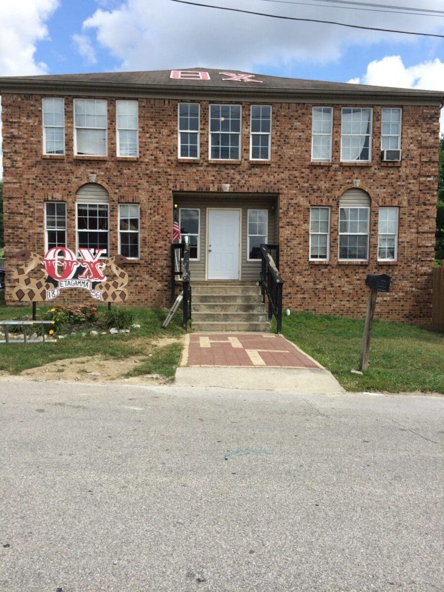 Brick building with steps and large front windows.