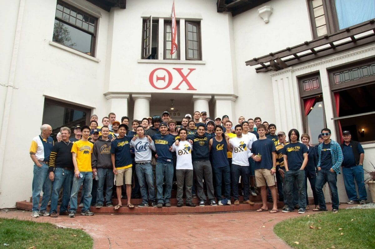 Group of fraternity members outside their house.